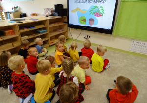 Dzieci oglądają prezentację o jesieni.